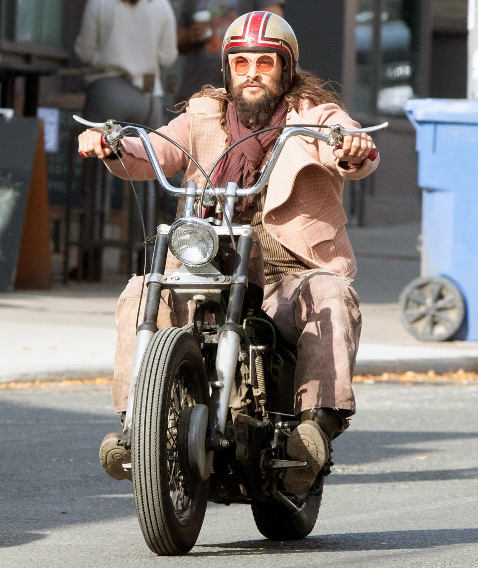 <p>Jason Momoa wears a pink jacket and sunglasses as he takes his motorcycle for a spin in Toronto, Canada on Sunday. </p>