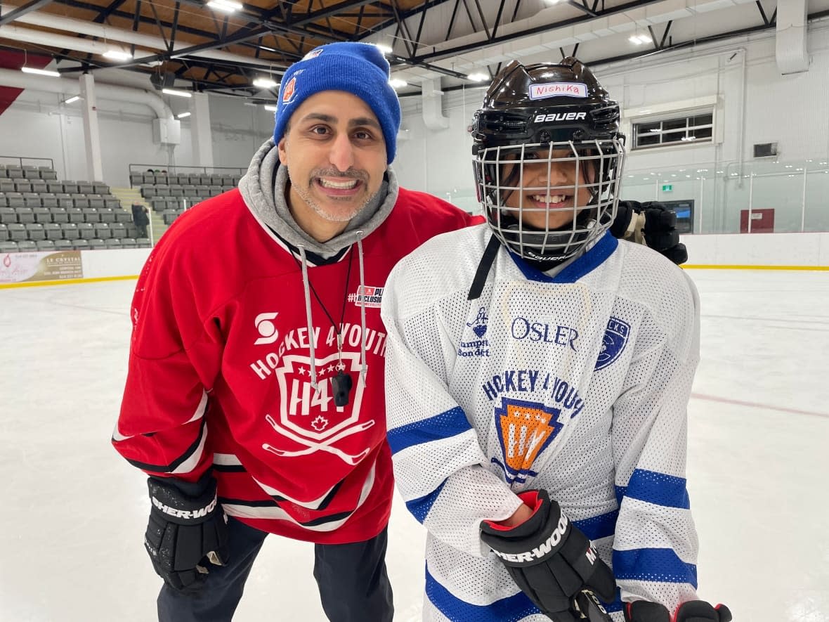 Nishika Venkatachalam, right, is part of a group of students who are learning the basics of hockey over a 10-week period for free. Moezine Hasham, left, the executive director for the Hockey 4 Youth Foundation, says the goal is to remove barriers to the sport. (Sharon Yonan Renold/CBC - image credit)