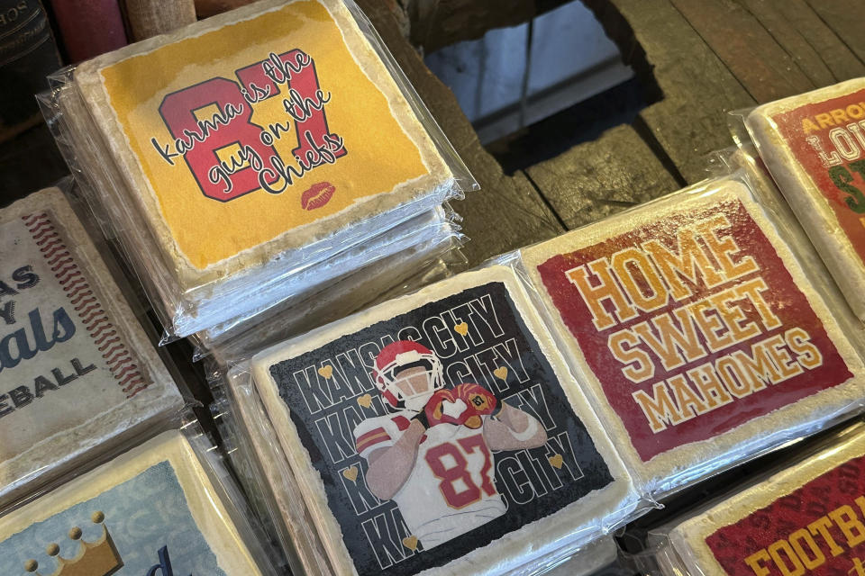 Coasters from Westside Storey are on display in Kansas City, Mo., on Monday, Feb. 5, 2024. Coasters, mugs, t-shirts, candles, posters, artwork are some of the items being sold to commemorate the relationship between Taylor Swift and Travis Kelce. (AP Photo/Nick Ingram)
