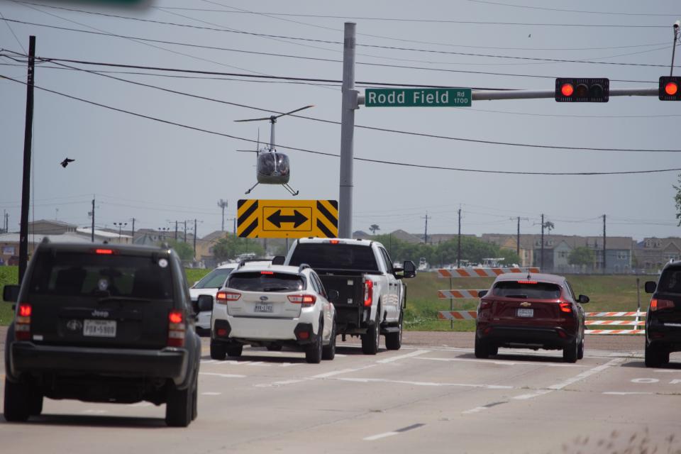 A helicopter flies over the intersection of Williams and Rodd Field roads during an investigation Monday afternoon.