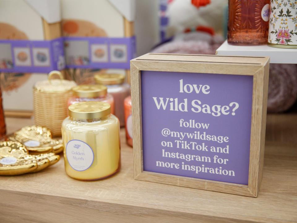 Wild Sage products by a sign asking customers to follow the brand on TikTok and Instagram