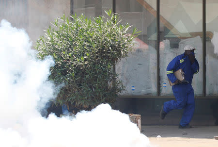A man runs from teargas during clashes between police and street vendors in central Harare, Zimbabwe, September 27, 2016. REUTERS/Philimon Bulawayo
