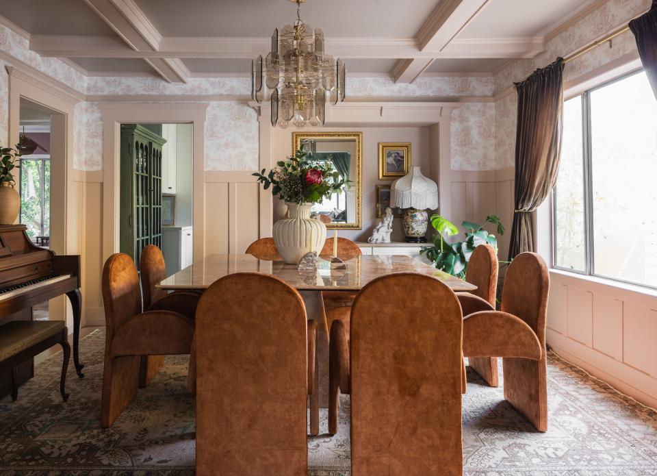 The dining room is the heart of the home, and Francesca’s preferred spot for entertaining. As she tells it, it took six people to haul in the vintage onyx dining table, originally from Italy, “but the effort was well worth it in my eyes.” She offset the peachy orange tones of the table with a hushed vintage Turkish rug, curtains from Wayfair, and One Allium Way’s Chateau Toile wallpaper.