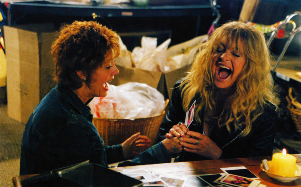 Susan Sarandon and Goldie Hawn laugh while holding up some polaroid pictures as Lavinia and Suzette