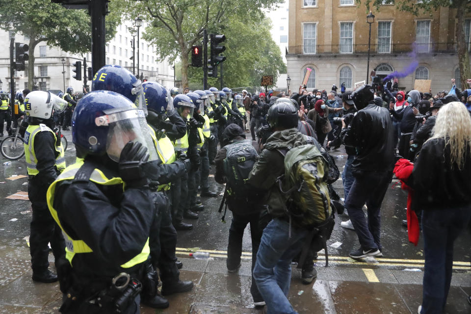 Police faces demonstrators after scuffles during a Black Lives Matter march in London, Saturday, June 6, 2020, as people protest against the killing of George Floyd by police officers in Minneapolis, USA. Floyd, a black man, died after he was restrained by Minneapolis police while in custody on May 25 in Minnesota. (AP Photo/Frank Augstein)