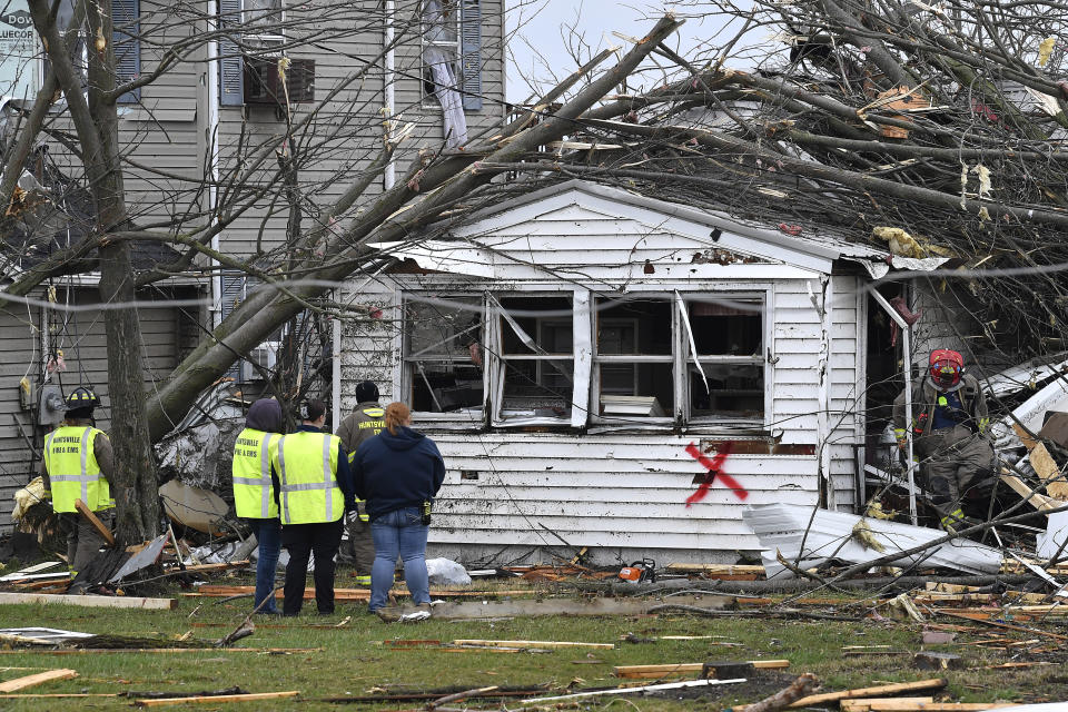 Members of the Huntsville Volunteer Fire Department mark houses with a red x to signify that they have been search for victims following severe storms in Lakeview, Ohio., Friday, March 15, 2024. Severe storms with suspected tornadoes have damaged homes and businesses in the central United States. (AP Photo/Timothy D. Easley)