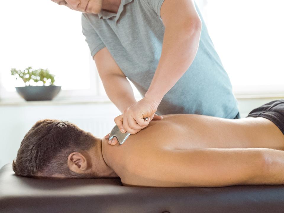 An individual receives a massage using the Graston technique.