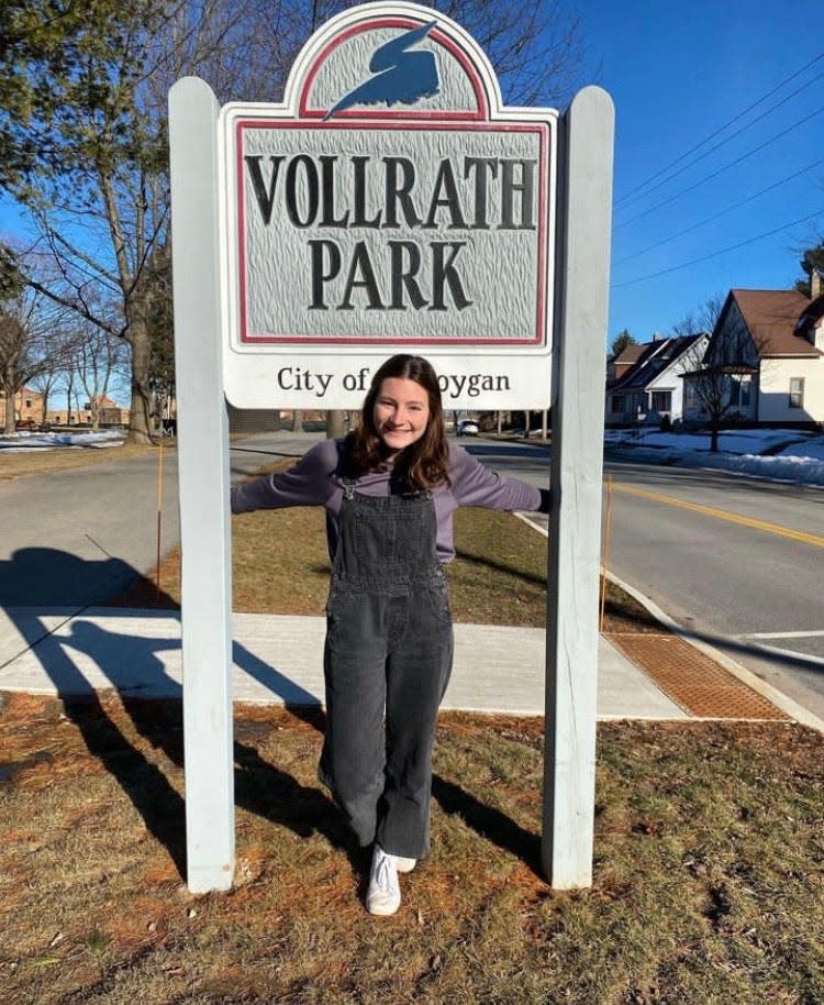 Eileen English smiles in front of the Vollrath Park sign, the site of her project, Beat! A Musical Garden.