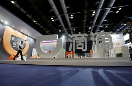 FILE PHOTO: A staff member walks at Didi Chuxing's booth at the Global Mobile Internet Conference (GMIC) 2017 in Beijing, China April 28, 2017. REUTERS/Jason Lee