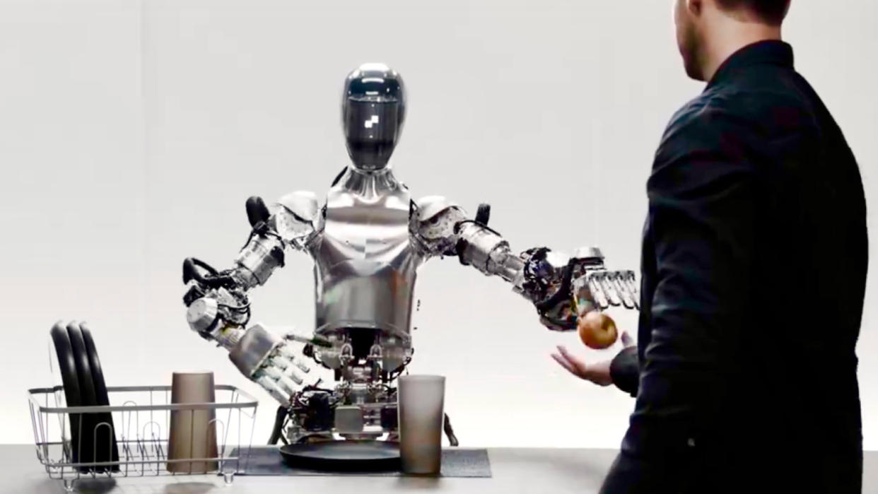  Artificial intelligence robot (left) hands an apple to a man (right). 