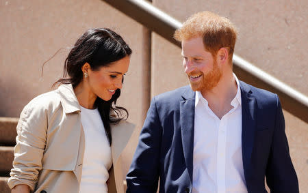 Britain's Prince Harry and wife Meghan, Duchess of Sussex share a moment as they walk during a visit at the Sydney Opera House in Sydney, Australia October 16, 2018. REUTERS/Phil Noble