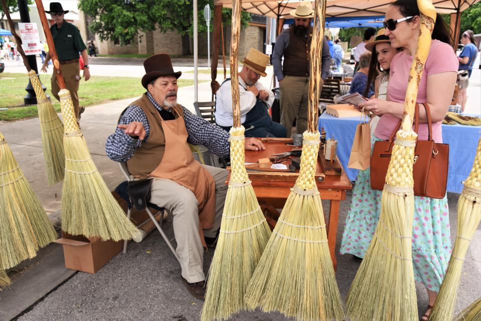 John Potter, left, displays pioneer-era handmade brooms at Yesterfest 2023. Potter operates the Republic of Texas Broom Shop & 1800’s General Store in New Braunfels.