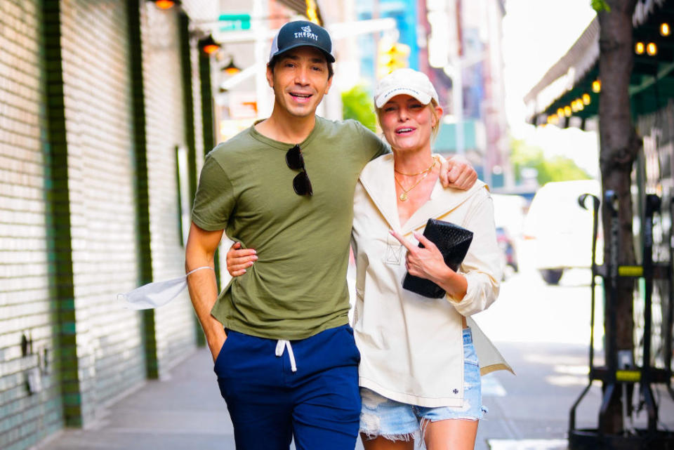 Justin and Kate wearing caps and embracing on the street