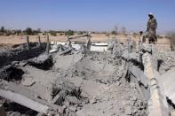 Houthi fighters stand on the rubble of an army weapons depot destroyed by an air strike in Yemen's northwestern city of Saada April 1, 2015. REUTERS/Naiyf Rahma