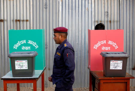 A police officer walks past ballot boxes at a polling station during the parliamentary and provincial elections at Chautara in Sindhupalchok District November 26, 2017. REUTERS/Navesh Chitrakar