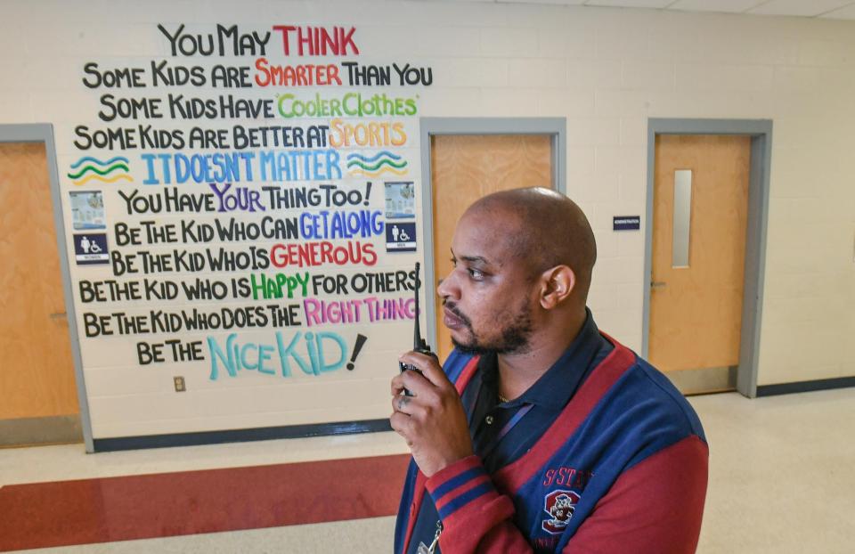 Brian Williams, Principal at Robert Anderson Middle School in Anderson, S.C. uses radio to communicate while walking to classes Wednesday, April 24, 2024.