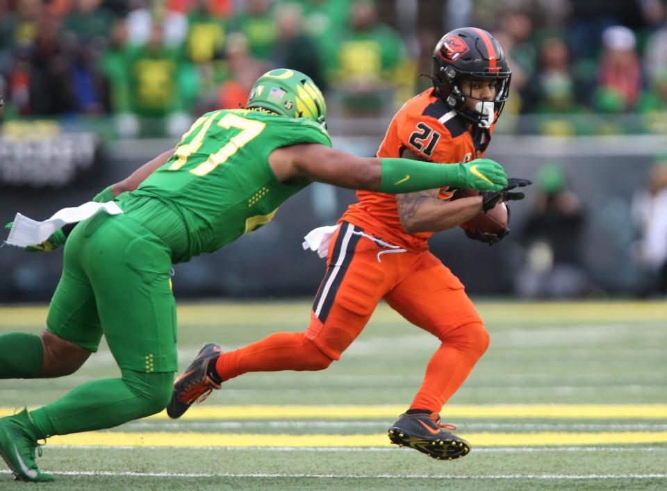 Oregon's Mase Funa, left, tries to run down Oregon State's Trey Lowe during the third quarter.