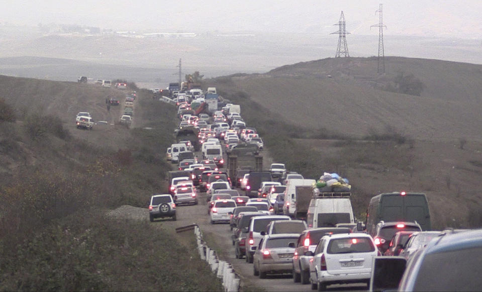 In this photo taken from the Associated Press Television video, people stuck in a traffic jam as they leave the separatist region of Nagorno-Karabakh to Armenia, Saturday, Nov. 7, 2020. Many thousands of ethnic Armenians are fleeing Nagorno-Karabakh as Azerbaijanian forces continue their advance. (AP Photo)