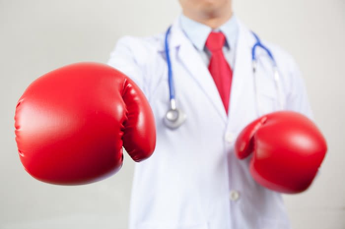 A doctor wearing red boxing gloves.
