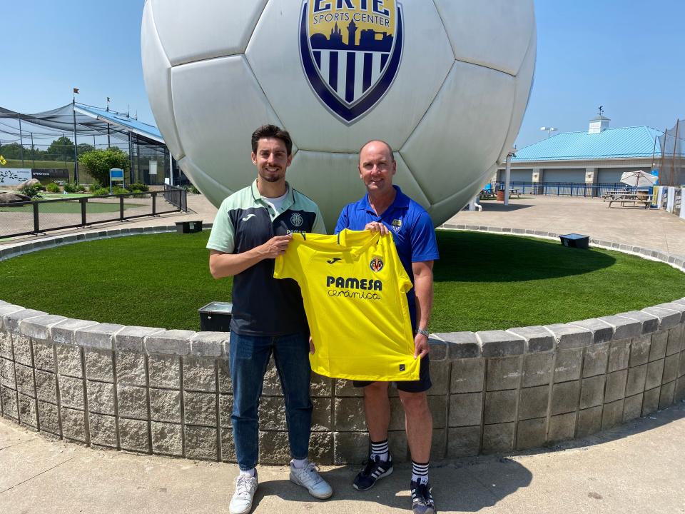 Villarreal Academy international technical director David Navarro (left) and Erie Sports Center owner Troy Bingham hold a Villarreal CF jersey on the campus of ESC in Summit Township. Navarro visited Erie May 30 ahead of the club’s announced partnership with ESC.