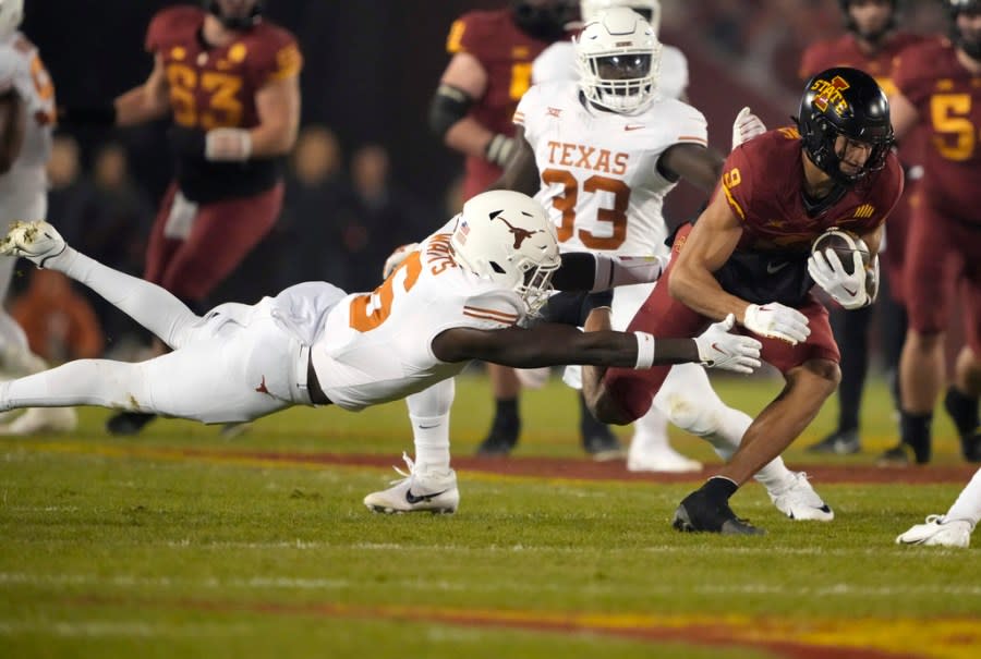 Texas defensive back Ryan Watts (6) dives to tackle Iowa State wide receiver Jayden Higgins (9) during the first half of an NCAA college football game, Saturday, Nov. 18, 2023, in Ames, Iowa. (AP Photo/Matthew Putney)