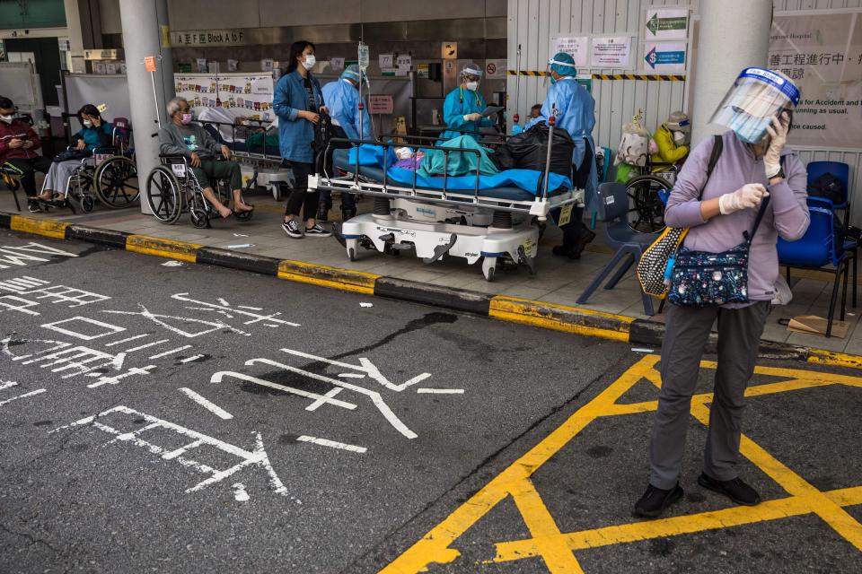 Health workers wearing personal protective equipment (PPE) treat patients in a holding area outside the accident and emergency department of Princess Margaret hospital in Hong Kong on March 11, 2022 as the city is facing its worst-ever Covid-19 coronavirus outbreak and has since seen overflowing hospitals and morgues, shortages of medics and ambulances and a frantic expansion of the city's spartan quarantine camp system.