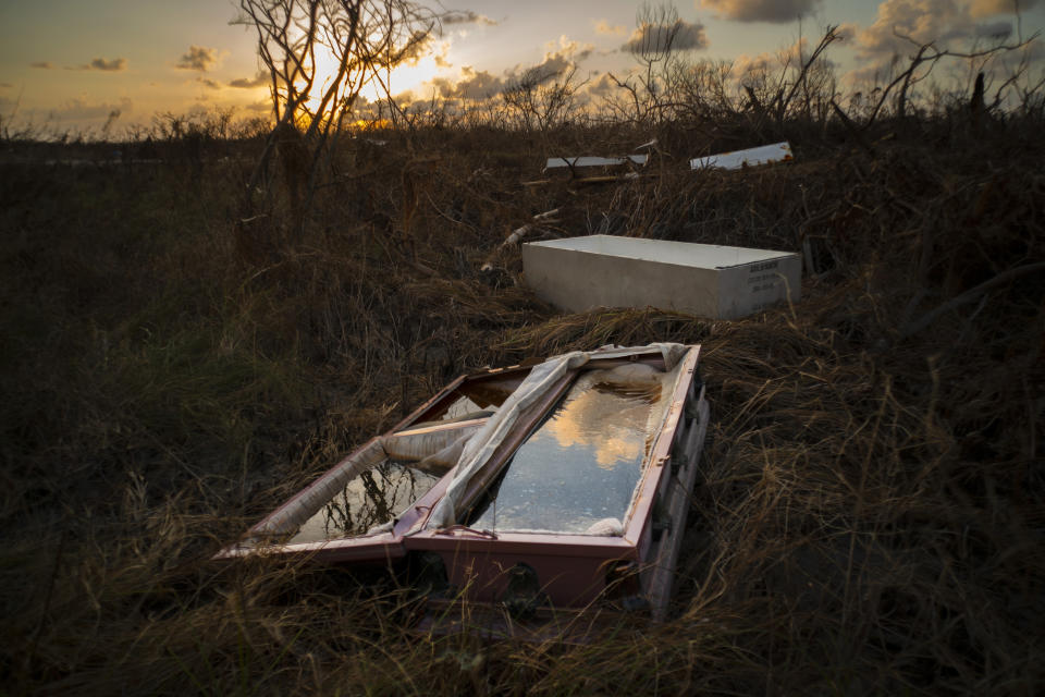 In this Sept. 11, 2019 photo, a shattered and water-filled coffin lays exposed to the elements in the aftermath of Hurricane Dorian, at the cemetery in Mclean's Town, Grand Bahama, Bahamas. Bahamians are tackling a massive clean-up a week after Hurricane Dorian devastated the archipelago's northern islands. (AP Photo/Ramon Espinosa)