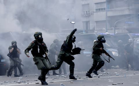 Military police fight back against demonstrators, who threw stones and burned barricades outside the doors of Argentina's congress - Credit: Natacha Pisarenko /AP