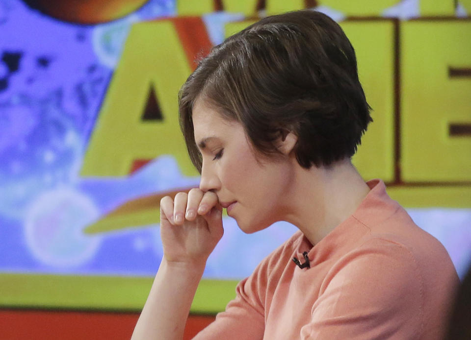 Amanda Knox puts her hand to her face while making a television appearance, Friday, Jan. 31, 2014 in New York. Knox said she will fight the reinstated guilty verdict against her and an ex-boyfriend in the 2007 slaying of a British roommate in Italy and vowed to "never go willingly" to face her fate in that country's judicial system . "I'm going to fight this to the very end," she said in an interview with Robin Roberts on ABC's "Good Morning America." (AP Photo/Mark Lennihan)
