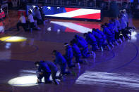 Golden State Warriors players and coaches kneel during the national anthem before an NBA basketball game against the Los Angeles Clippers in San Francisco, Wednesday, Jan. 6, 2021. (AP Photo/Jeff Chiu)