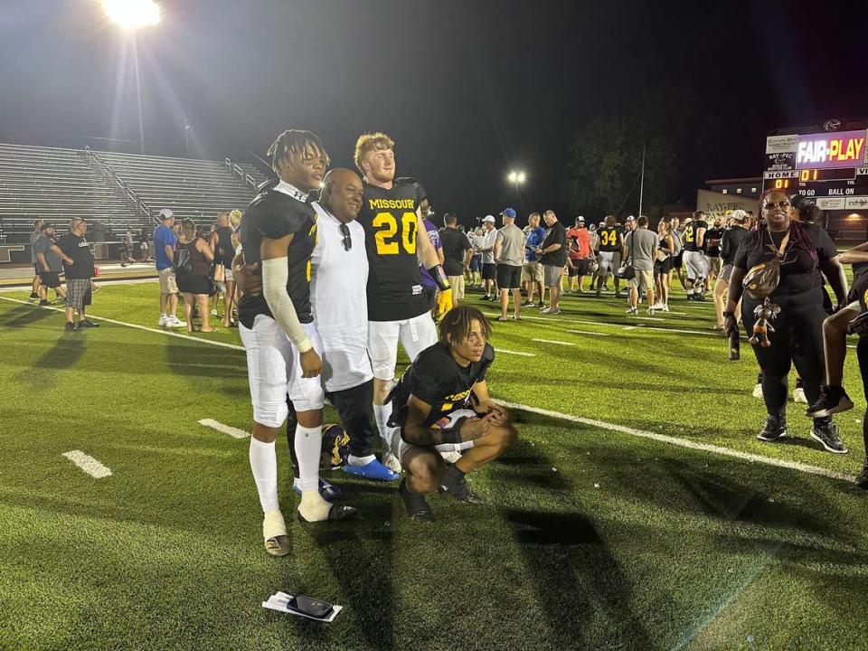 Blue Springs teammates Joe Whie (far left), Eli Youman (No. 20, standing) and Kaden Lutjen-Williams (squatting down) pose after winning the Kansas-Missouri All-Star Football Game at Ray-Pec HS on June 16, 2023.