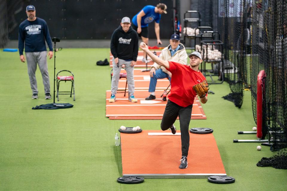 Connor Van Scoyoc, a right-handed pitcher in the Los Angeles Angels' organization, throws a pitch during a bullpen session at Dugout Sports in Fairfax on Jan. 24. Van Scoyoc's grandfather, Jim, sits in a chair behind him and watches.