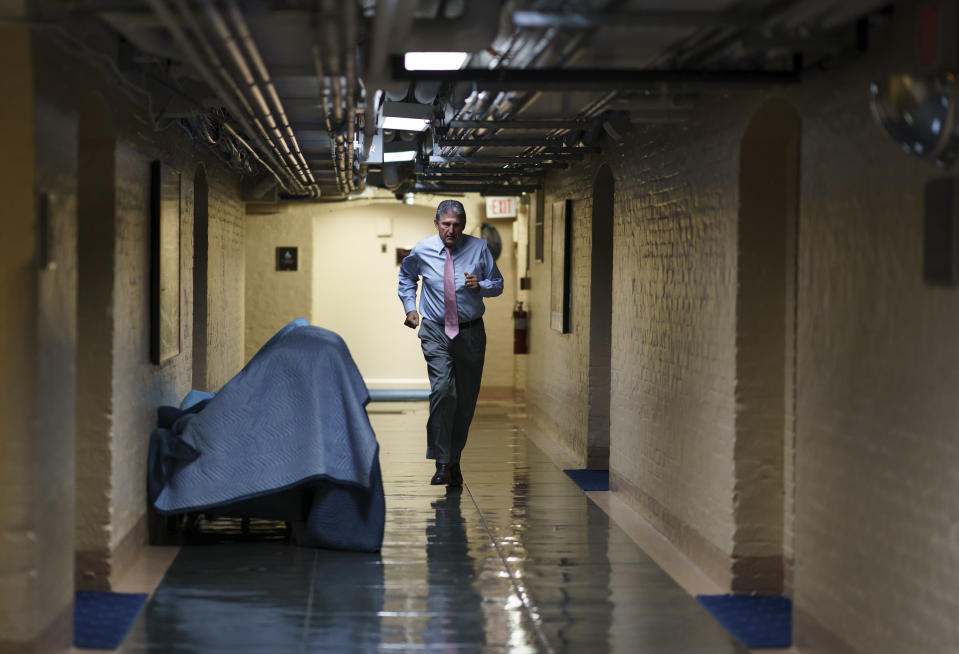 FILE - In this June 16, 2021, file photo Sen. Joe Manchin, D-W.Va., one of the key Senate infrastructure negotiators, rushes back to a basement room at the Capitol as he and other Democrats work behind closed doors, in Washington. Congress is hunkered down, grinding through an eight-week stretch as the president’s Democratic allies in the House and Senate try to shape his big infrastructure ideas into bills that could actually be signed into law. Perhaps not since the drafting of Obamacare more than a decade ago has Washington tried a legislative lift as heavy as this. (AP Photo/J. Scott Applewhite, File)