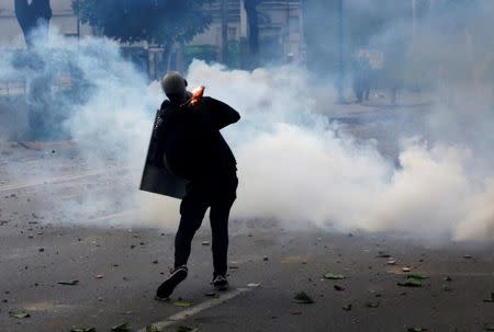 A demonstrator throws a petrol bomb while clashing with riot security forces during a strike called to protest against Venezuelan President Nicolas Maduro's government in Caracas, Venezuela, July 20, 2017. REUTERS/Carlos Garcia Rawlins