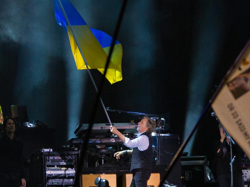 Paul McCartney waves the Ukrainian flag while performing on the Pyramid stage at Glastonbury Festival (Joel C Ryan/Invision/AP)