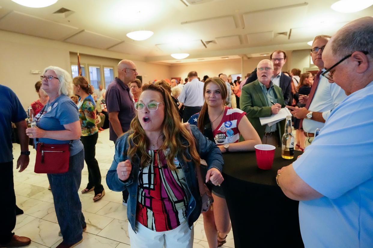 Alyssa and Mike Perry, of Hilliard, watch Issue 1 results come in during an election night party at the Columbus Fire Fighters Local 67.