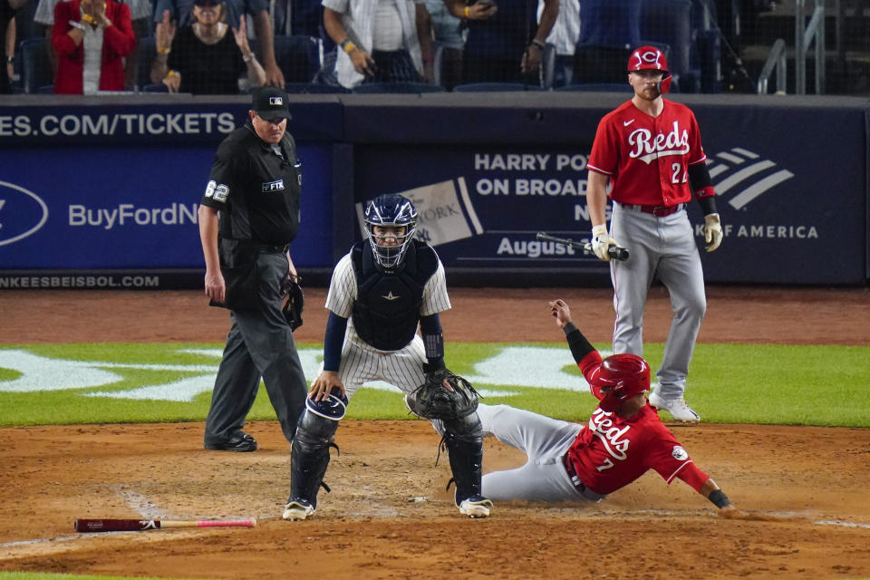 Cincinnati Reds' Brandon Drury (22) watches as Donovan Solano (7) slides past New York Yankees catcher Jose Trevino to score on a single by Jonathan India during the ninth inning of a baseball game Tuesday, July 12, 2022, in New York. The Reds won 4-3. (AP Photo/Frank Franklin II)