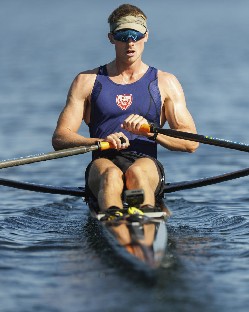 Tom Mackintosh rows on New Zealand's Lake Karapiro, Wednesday April 3, 2024. Sitting in an office, with his body sore behind a desk, Mackintosh had enough. After five months in the corporate world, the New Zealander rowing gold-medalist couldn't take it anymore. It was time to get back on the boat to try to win another Olympic medal at the Paris Games. (Stephen Parker/Photosport via AP)