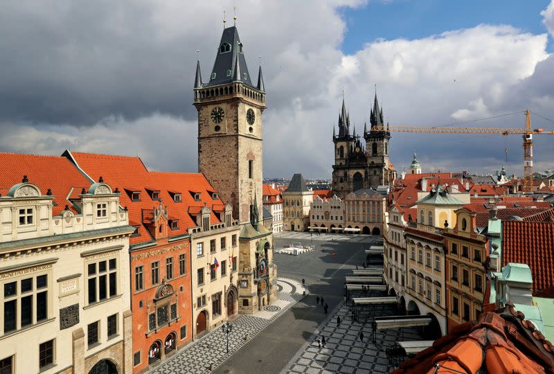 FILE PHOTO: A clock showing the time at noon, is pictured on a building, next to almost empty streets at Old Town Square during the coronavirus disease (COVID-19) outbreak, in Prague