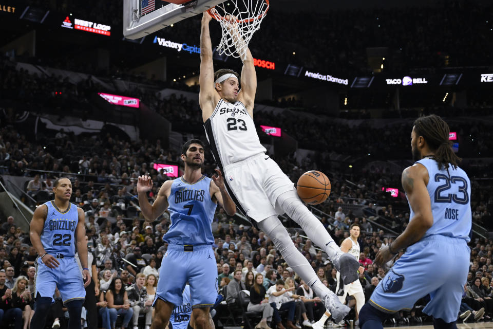 San Antonio Spurs' Zach Collins (23) dunks as Memphis Grizzlies' Derrick Rose (23), Santi Aldama (7) and Desmond Bane watch during the first half of an NBA basketball game Saturday, Nov. 18, 2023, in San Antonio. (AP Photo/Darren Abate)