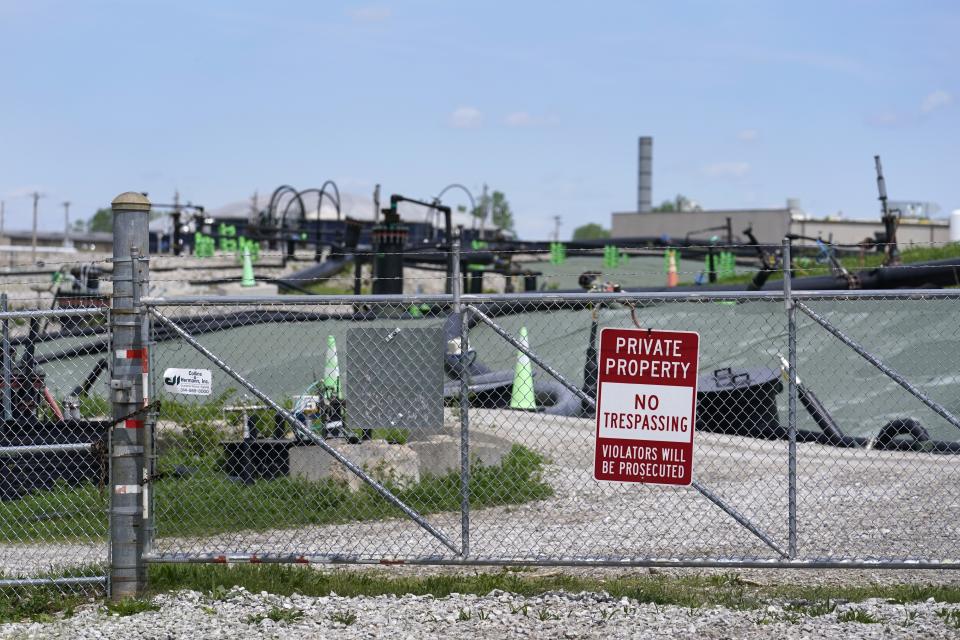FILE - A no trespassing sign hangs on a fence around the West Lake Landfill Superfund site on Friday, April 21, 2023, in Bridgeton, Mo. St. Louis activists have been fighting for years to get government compensation for people with cancer and other serious illnesses potentially connected to Manhattan Project nuclear contamination. (AP Photo/Jeff Roberson, File)