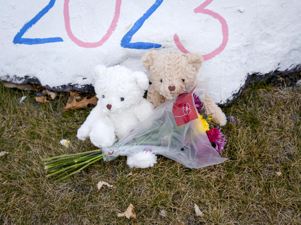 A pair of stuffed animals sit with flowers on the grounds of the Perry High School on Friday, Jan. 5, 2024, in Perry, Iowa, the day after a shooting. (AP Photo/Bryon Houlgrave)