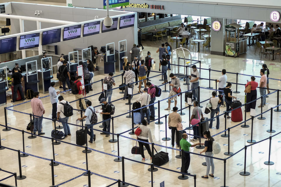 Tourists wait to check in at the airport in Cancun, Mexico, Saturday, June 13, 2020. In Quintana Roo state, where Cancun is located, tourism is the only industry there is, and Cancun is the only major Mexican resort to reopen so far. (AP Photo/Victor Ruiz)