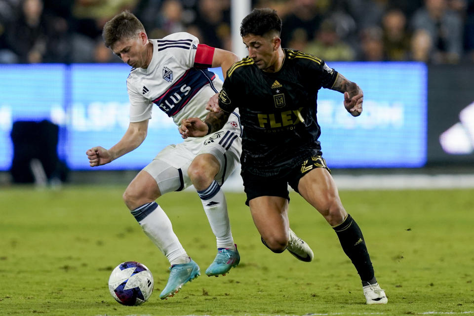 Los Angeles FC forward Cristian Olivera, right, and Vancouver Whitecaps midfielder Ryan Gauld vie for the ball during the second half of an MLS playoff soccer match Saturday, Oct. 28, 2023, in Los Angeles. (AP Photo/Ryan Sun)