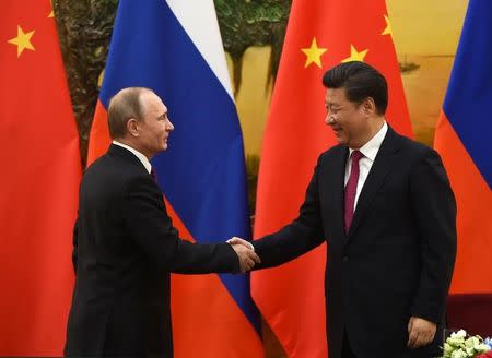 Russian President Vladimir Putin (L) shakes hands with Chinese President Xi Jinping at the end of a joint press briefing in Beijing's Great Hall of the People June 25, 2016. REUTERS/Greg Baker/Pool