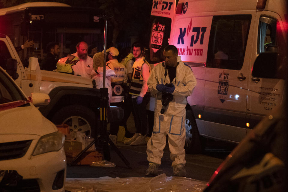 An Israeli police officer investigates the scene of a stabbing attack in the town of Elad, Israel, Thursday, May 5, 2022. Israeli medics say at least three people were killed in a stabbing attack near Tel Aviv on Thursday night. Israeli police said they suspect it was a militant attack. (AP Photo/Maya Alleruzzo)