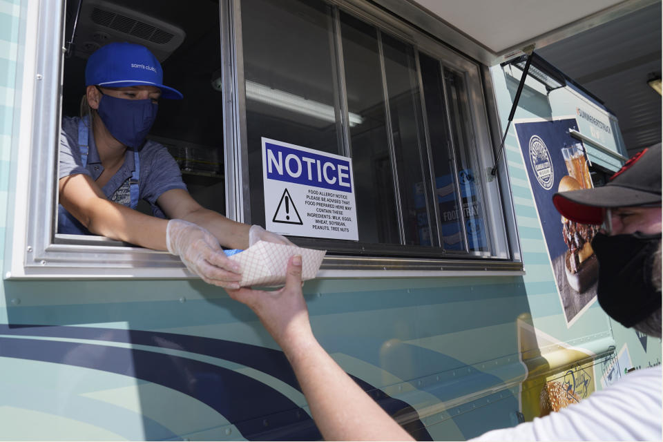 Tiffany Sawczenko hands a a food sample to a man that identified himself as Zeiis Friday, June 18, 2021, in McKinney, Texas. When the pandemic was declared in March 2020, retailers worried about the potential spread of the coronavirus so they cut off free sampling of everything from food to makeup to toys. But now with vaccinations rolling out and the threat of COVID-19 easing in the U.S., food vendors and stores are feeling confident enough to revive the longstanding tradition.(AP Photo/LM Otero)