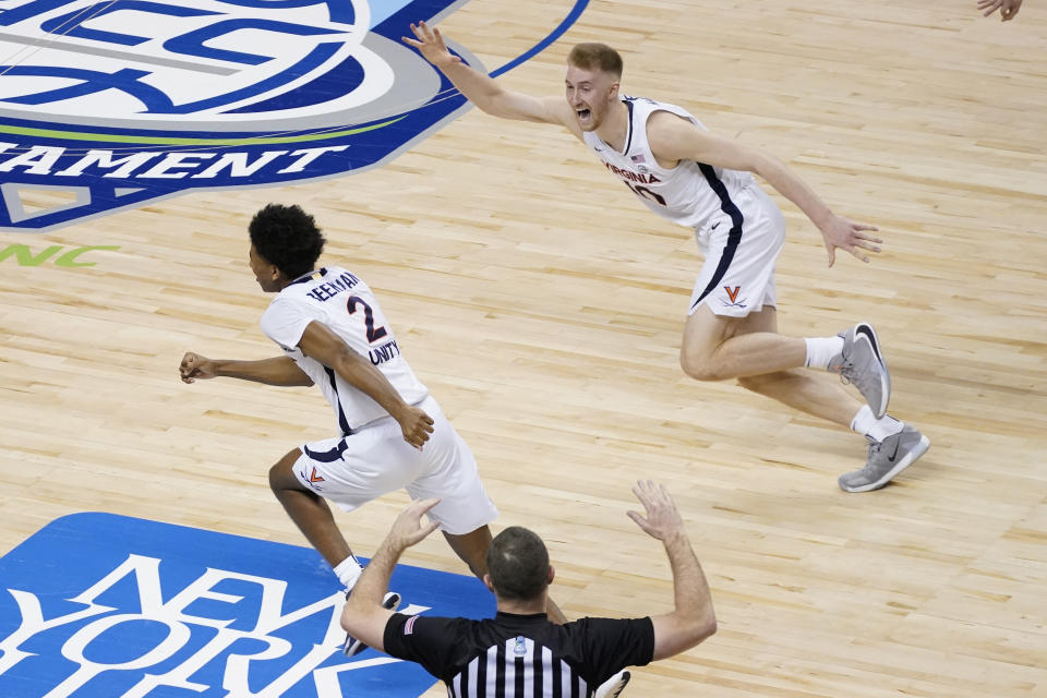 Virginia guard Reece Beekman (2) and Virginia forward Sam Hauser (10) celebrate Beekman's game winning shot during the second half of an NCAA college basketball game against Syracuse in the quarterfinal round of the Atlantic Coast Conference tournament in Greensboro, N.C., Thursday, March 11, 2021. Virginia won the game 72-69. (AP Photo/Gerry Broome)