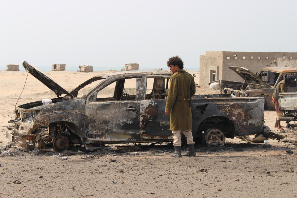 A Yemeni southern separatist fighter inspects the wreckage of government forces vehicles destroyed by UAE airstrikes near Aden, Yemen, Friday, Aug. 30, 2019. (AP Photo/Wail al-Qubaty)