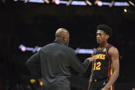 Atlanta Hawks head coach Nate McMillan, left, speaks to Atlanta Hawks forward De'Andre Hunter (12) during the first half of an NBA basketball game against the Miami Heat, Friday, Jan. 21, 2022, in Atlanta. (AP Photo/Hakim Wright Sr.)